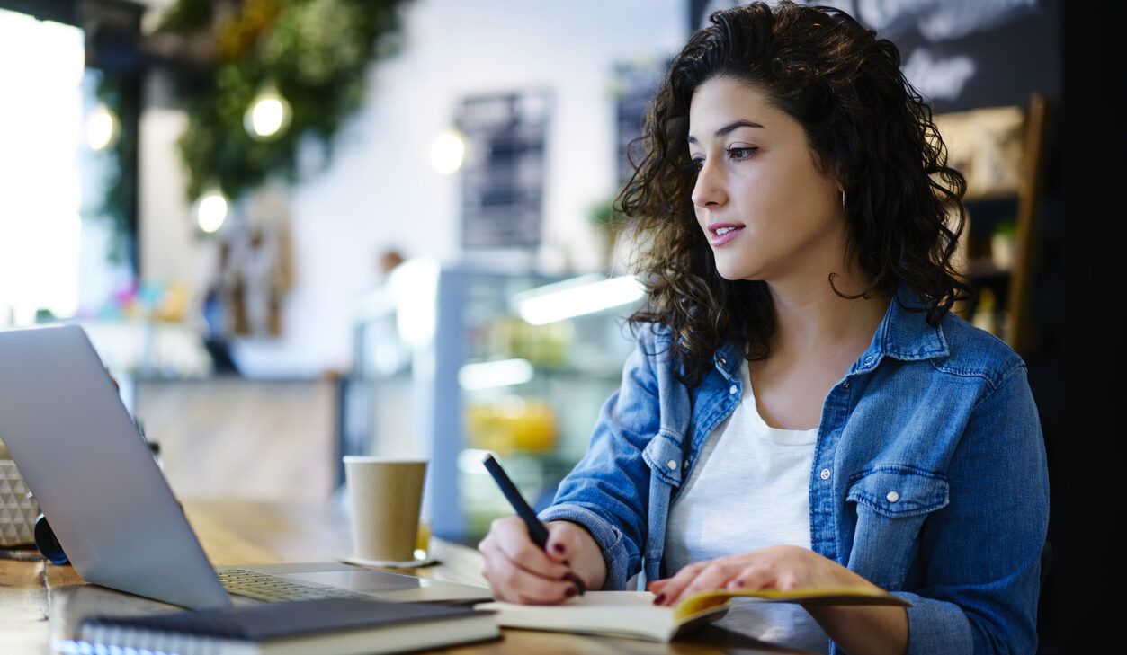 A woman writing the pros and cons of mailchimp abandoned cart series.